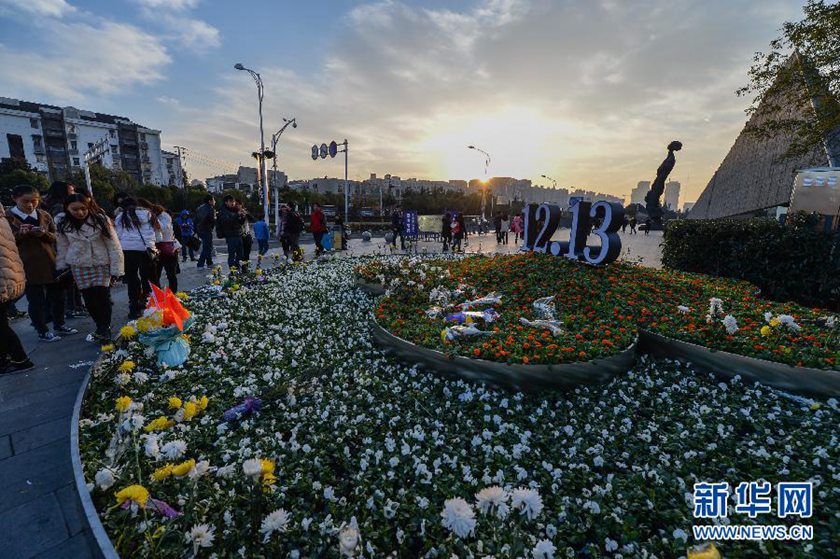 12月14日,觀眾在侵華日軍南京大屠殺遇難同胞紀(jì)念館前的“12·13”花壇上擺放鮮花祭奠遇難同胞。新華社記者 沈鵬 攝