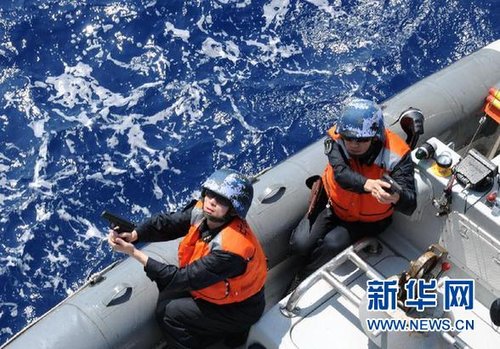 　3月28日，十余名臨檢拿捕隊員乘小艇駛至模擬可疑商船下方水面。