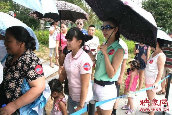 佩戴信息廣播臂貼的聽眾們?cè)谂抨?duì)等候坐帆船。