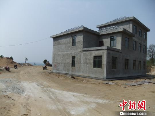 鴨河水庫(kù)庫(kù)區(qū)邊的新建別墅，一面墻上寫(xiě)著“拆”，另一邊在加緊施工。吳揚(yáng)　攝