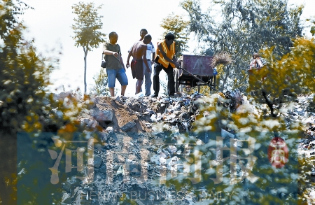 有人正在傾倒建筑垃圾，不遠(yuǎn)處就是村民的水井